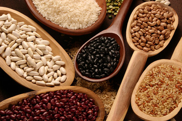 Grain sets peeled, rice and beans in wooden spoon
