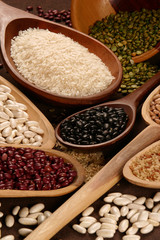 Grain sets peeled, rice and beans in wooden spoon