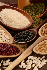 Grain sets peeled, rice and beans in wooden spoon