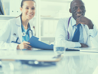 Two doctors working on an important folder in a medical office