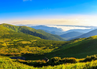 Carpathian mountains landscape in morning, panorama view from the height, Nesamovyte lake under hill.