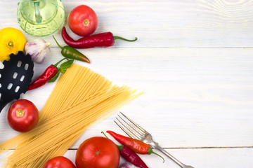 spaghetti with tomatoes on a white wooden background