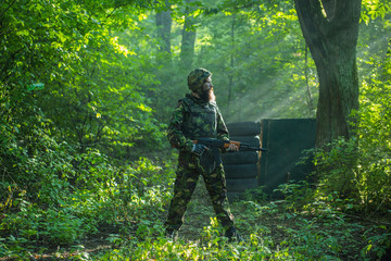 Soldier with rifle in forest