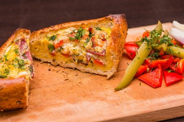 Traditional homemade omelet in bread crust. Special omelet with pickles, bacon, ham and cheese