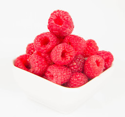 Raspberries: a bowl of fruit on white background