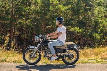 Obraz premium Young man riding his motorbike on open road