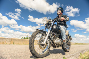 Fototapeta na wymiar Young man riding his motorbike on open road