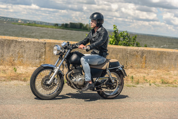 Fototapeta na wymiar Young man riding his motorbike on open road