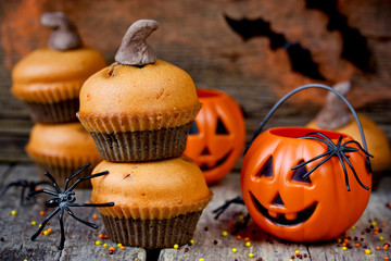Homemade Halloween pumpkin cupcakes on dark wooden background
