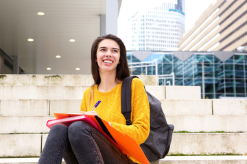 Smiling young woman writing in notebook