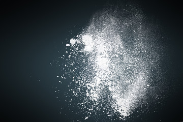 Abstract white powder against dark background