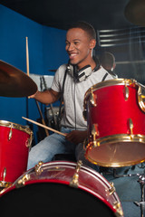 Drummer man playing on drums studio shot