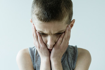 Fototapeta premium Troubled Young Boy Holding Face in Hands