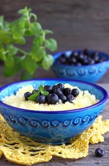 Maize porridge in bowl  with blueberries and mint. Healthy breakfast with vitamins.