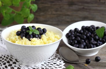 Maize porridge in bowl  with blueberries and mint. Healthy breakfast with vitamins.