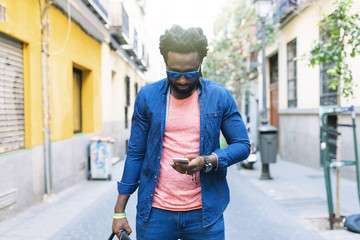African Young Man Using Mobile In The Street.