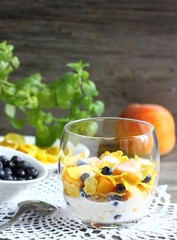 Maize porridge in bowl  with blueberries with  peach,  and mint. Healthy breakfast with vitamins.