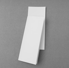 Four - fold white template paper on gray  background .