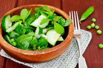 Salad with Cucumber, Purslane and Green Peas on Dark Disks
