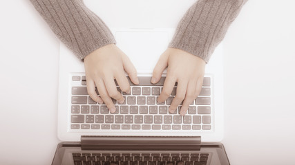 Fototapeta na wymiar Closeup of business woman hand typing on laptop keyboard,vintage