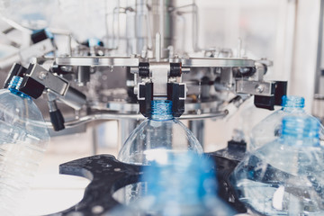 Water bottling line for processing and bottling pure spring water into bottles. Selective focus.