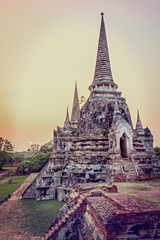 Fototapeta premium Vintage style add texture effect, ancient ruins and pagoda of Wat Phra Si Sanphet old temple famous attractions during sunset at Phra Nakhon Si Ayutthaya Historical Park, Ayutthaya Province, Thailand