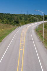 Curve on a Major Highway with Streetlamps and Blue Sky