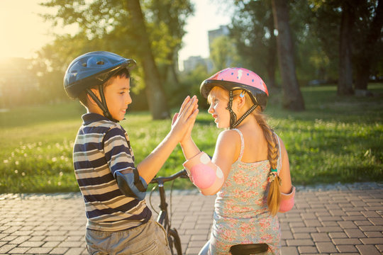 girl and boy riding bike in park