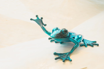 green ceramic frog with hand up in the air as display show for decoration