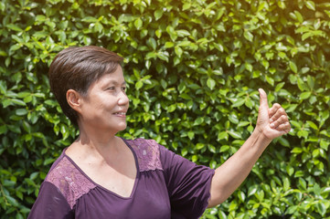 Senior Asian woman  looking thumbs up.