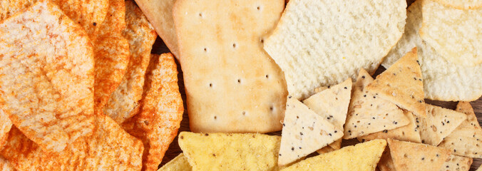 Heap of crunchy cookies and salted crisps, concept of unhealthy food
