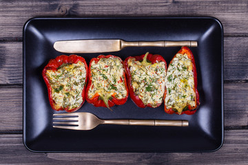 Stuffed red peppers in black plate