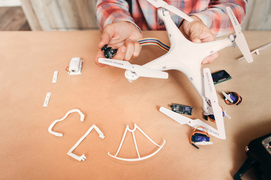 Electronics of disassembled drone repairing. Master connecting electronic elements to quadrocopter. Modern technologies, innovation, hobby, aeromodelling concept