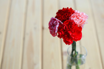 Red and pink of carnation flowers on wood