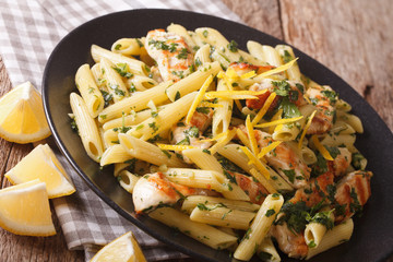 Penne Pasta with pesto, chicken breast and lemon closeup. horizontal
