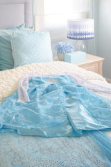 Fototapeta na wymiar Light blue princess dress on bed in light blue interior bedroom