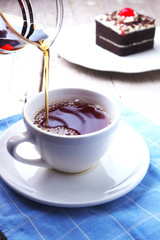 Close up of tea pouring into a cup from a glass teapot. selective focus.