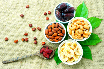 Top view of mixed dried fruits and nuts on a sackcloth background.