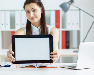 Young  woman holding tablet with copy space for text or picture. Stylish modern office workplace on a background.