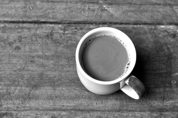 Hot coffee on old wooden plank in low key black and white style, Black and white photography