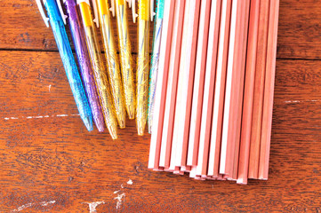 Colorful pens and pencils on rustic wooden background