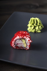 Sushi. Tobico Roll served on grey plate with wasabi.