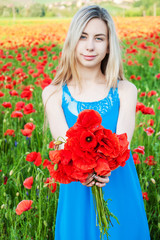 Obraz na płótnie Canvas young girl in the poppy field