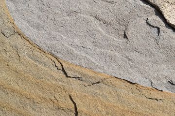 Sandstone. Texture.
The rough surface of yellow and gray sandstone.