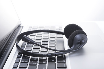 headset on keyboard computer laptop, call center support and customer service help, concept for...