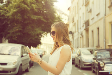Young fashionable woman using cellphone outdoors.

