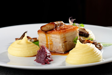 Plated freshly grilled pork belly with potato and mushrooms/fine dining