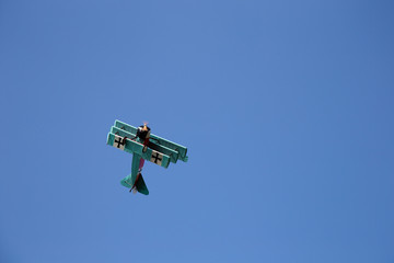Old Triplane flying on clear blue Sky - WWI Fokker