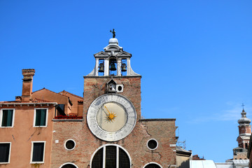 Picturesque clock tower in front of The Rialto Bridge in Venice, Italy.