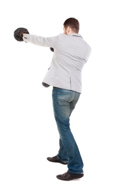 businessman with boxing gloves in fighting stance. guy in a gray jacket boxing gloves.